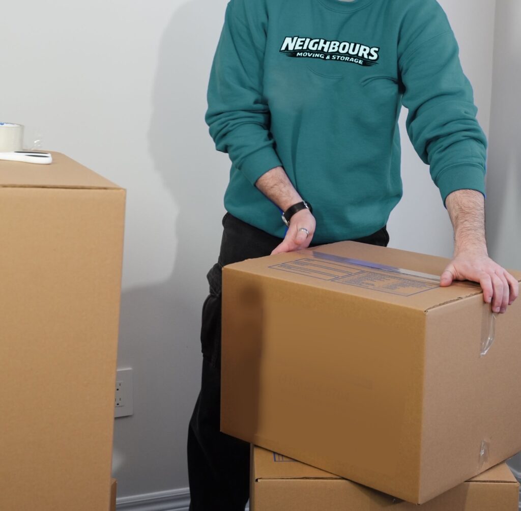 Neighbours Moving & Storage mover handling packed boxes, showcasing organized packing, careful lifting, and reliable residential moving services.