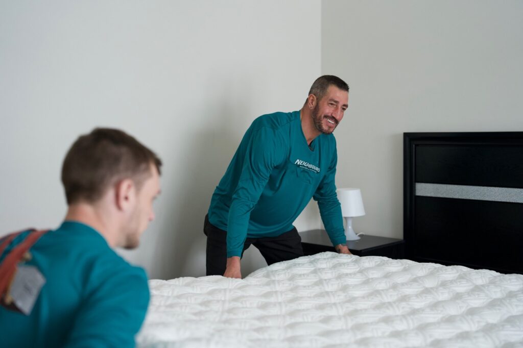 Neighbours Moving & Storage movers carefully setting up a mattress, showcasing reliable residential moving services and careful furniture handling.