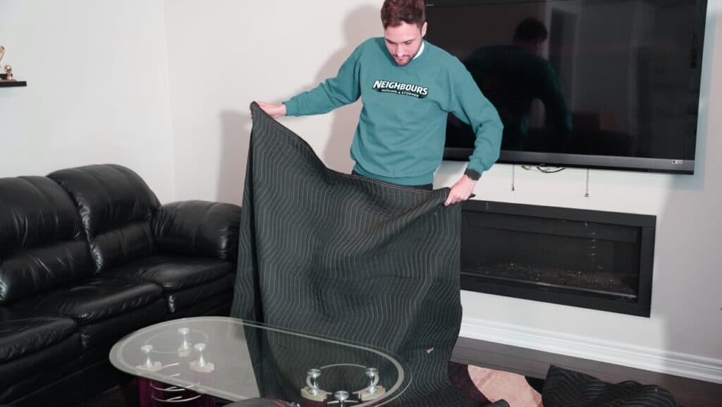 Heavy-duty moving blanket being prepared for transport by Neighbours Moving & Storage staff.