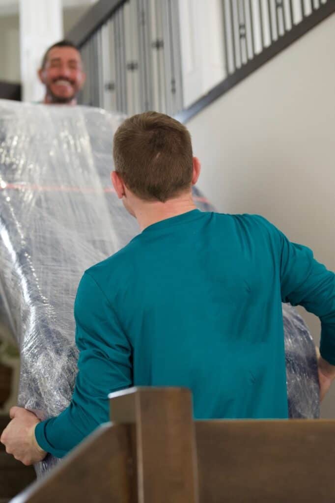 Moving professionals handling large furniture in a residential home for moving services.