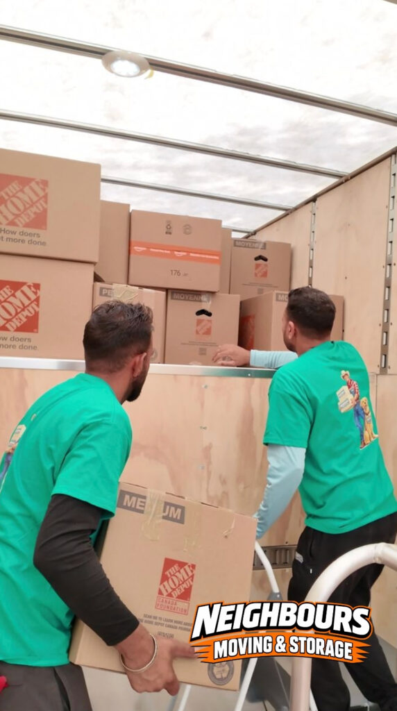 Professional movers carefully load labeled moving boxes into a moving truck for a safe, organized, and efficient residential relocation.